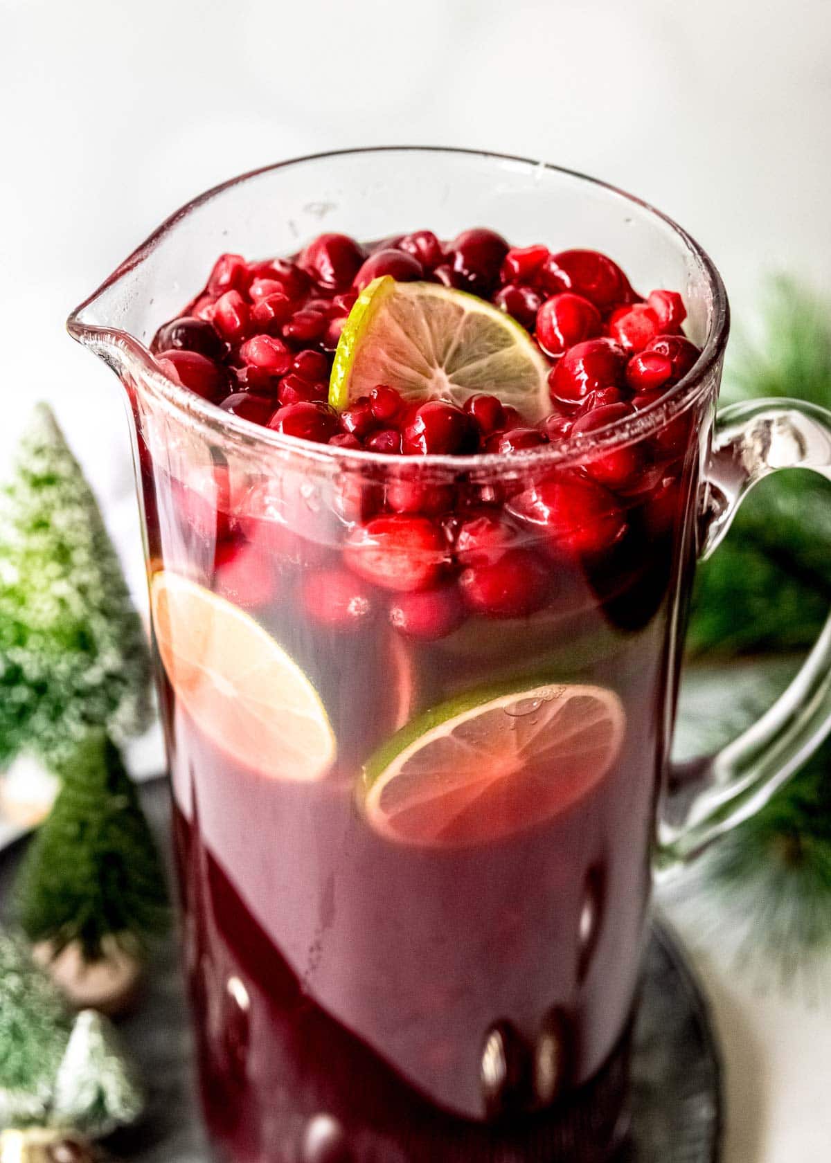 fresh cranberries and lime slices in a pitcher of christmas punch