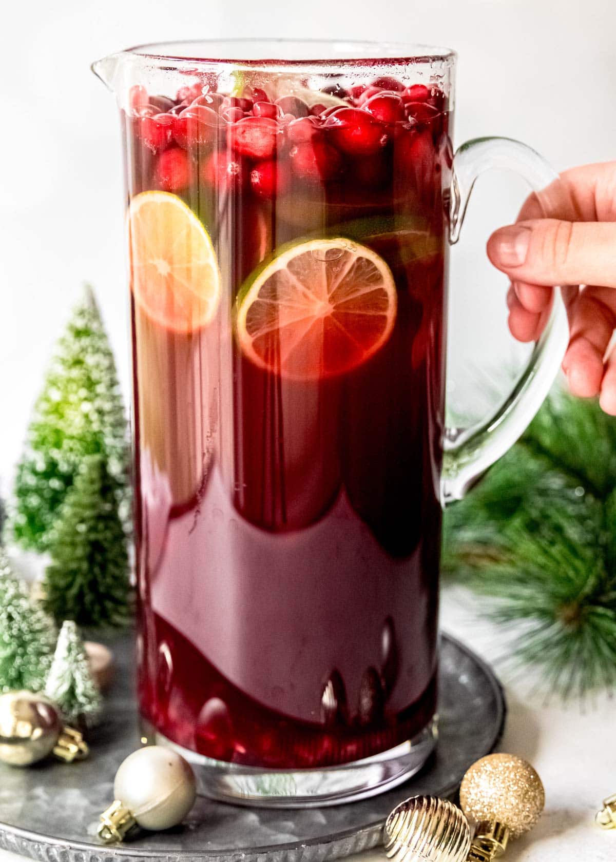 tall pitcher filled with cranberry pomegranate champagne punch for christmas
