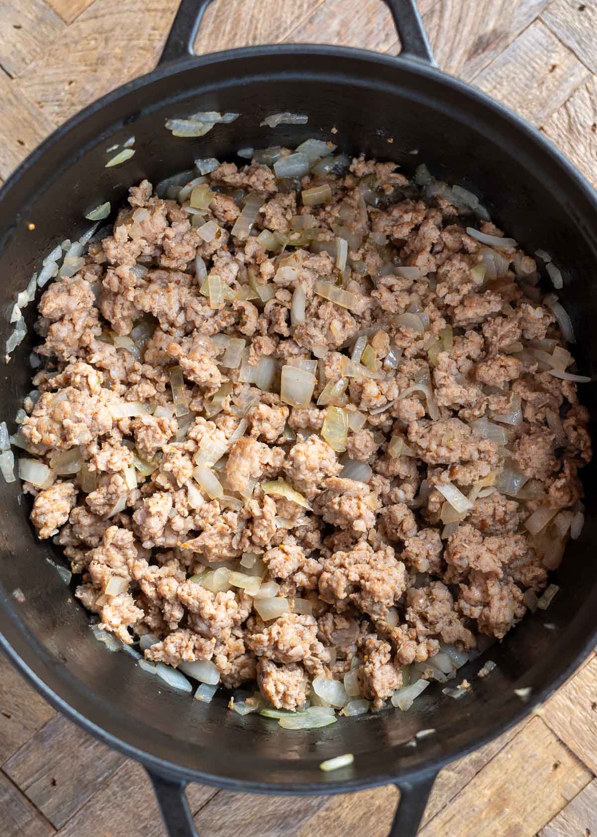 Italian sausage, onions, and garlic cooking in a pot
