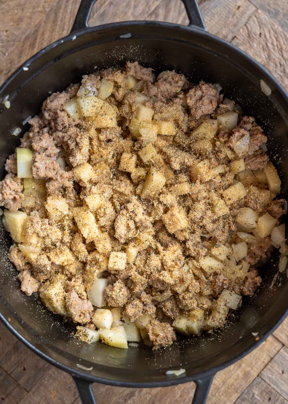 Italian sausage, onions, garlic, turnips, and seasonings in a pot