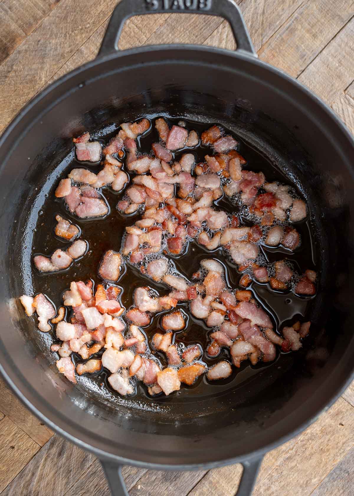 small bacon pieces crisping in a pan