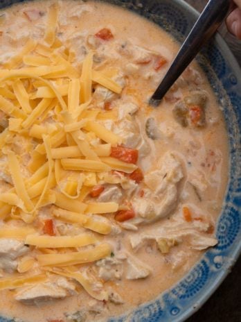 a creamy buffalo chicken soup in a blue bowl with a spoon