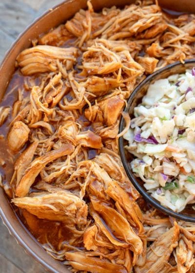 close up of instant pot bbq chicken in a brown bowl and slaw