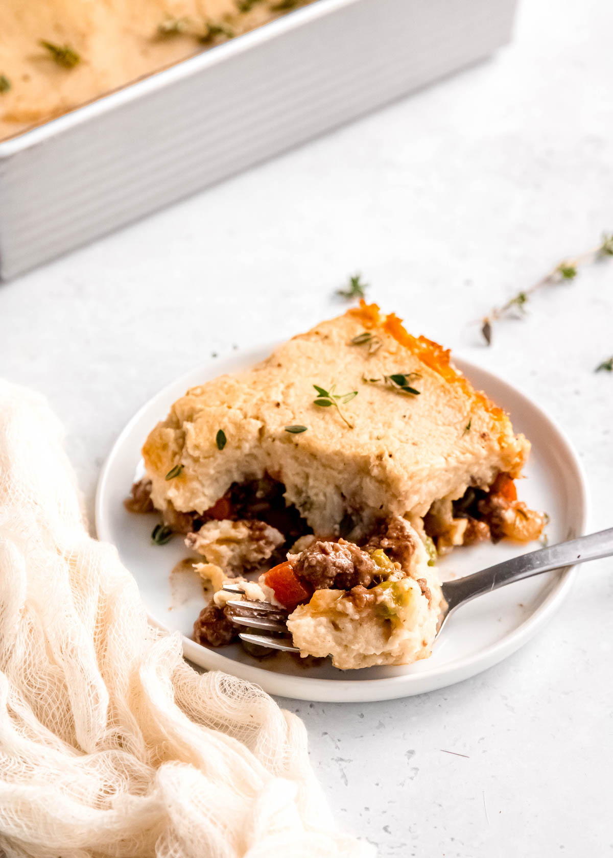 a slice of lightened up shepherd's pie and a bite of food on a fork
