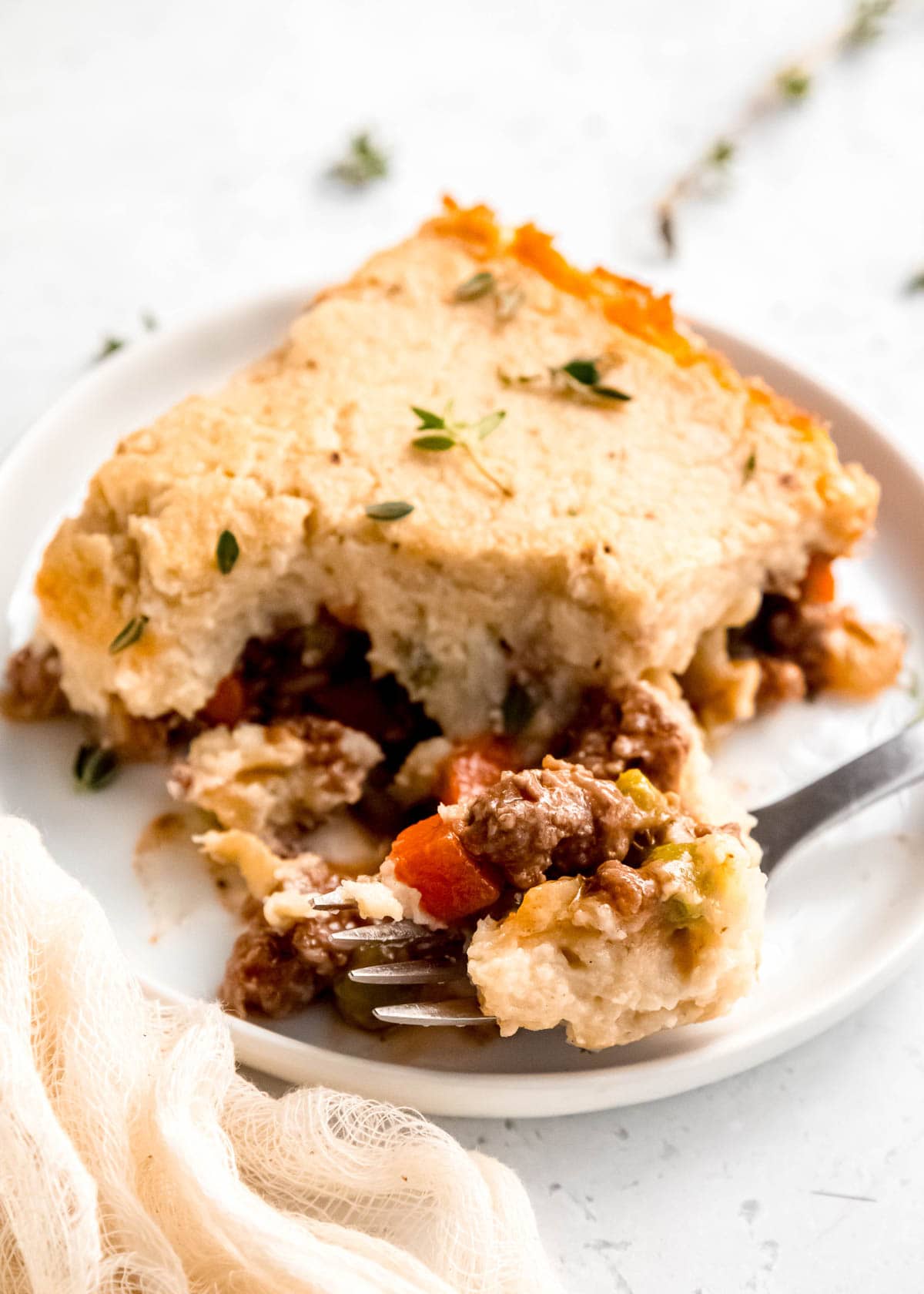 close up of a slice of lightened up shepherd's pie and a bite of food on a fork