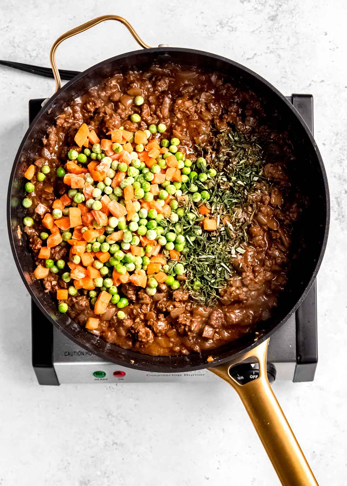 vegetables being added to meat mixture