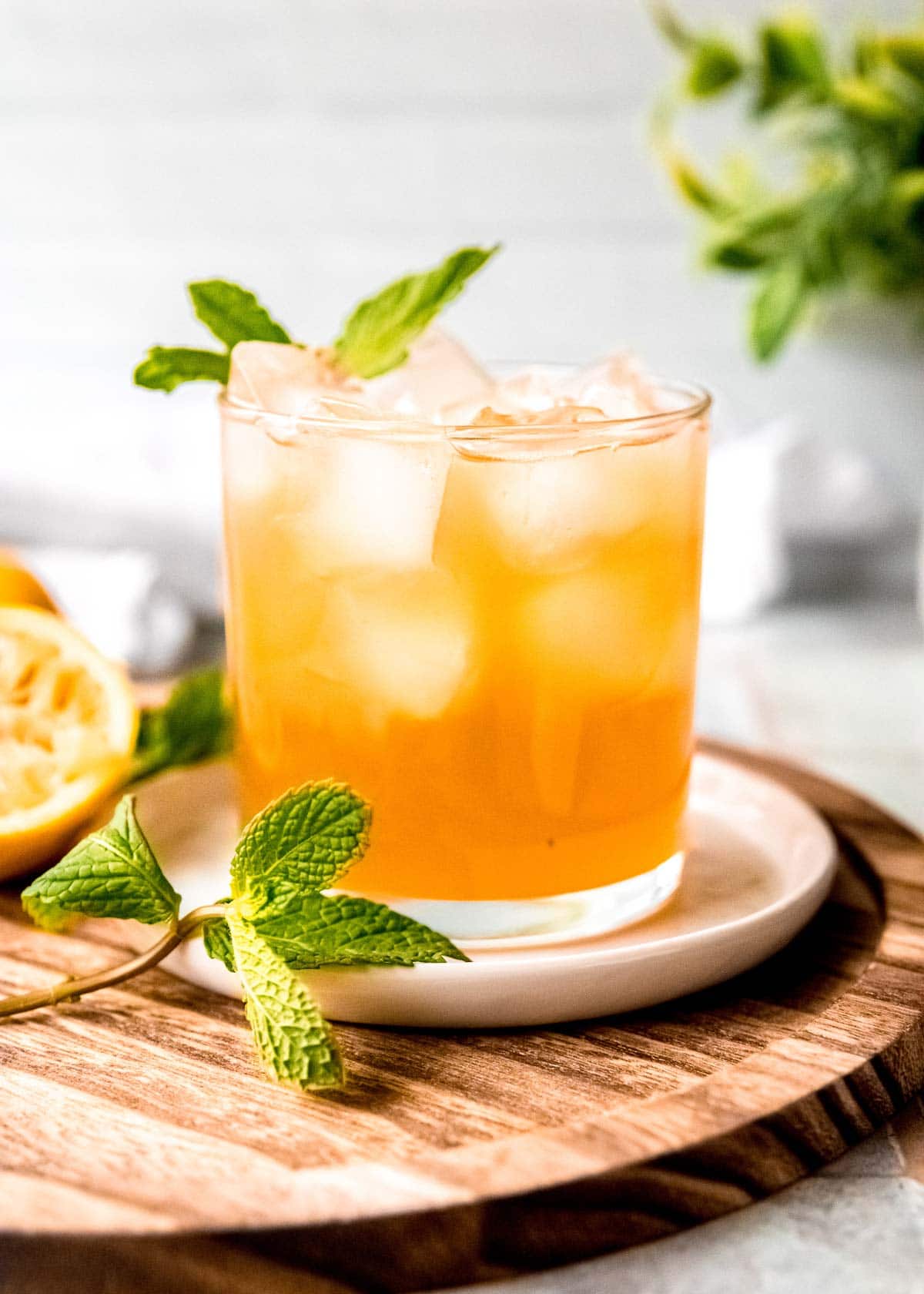 mint julep in a clear glass on a white plate