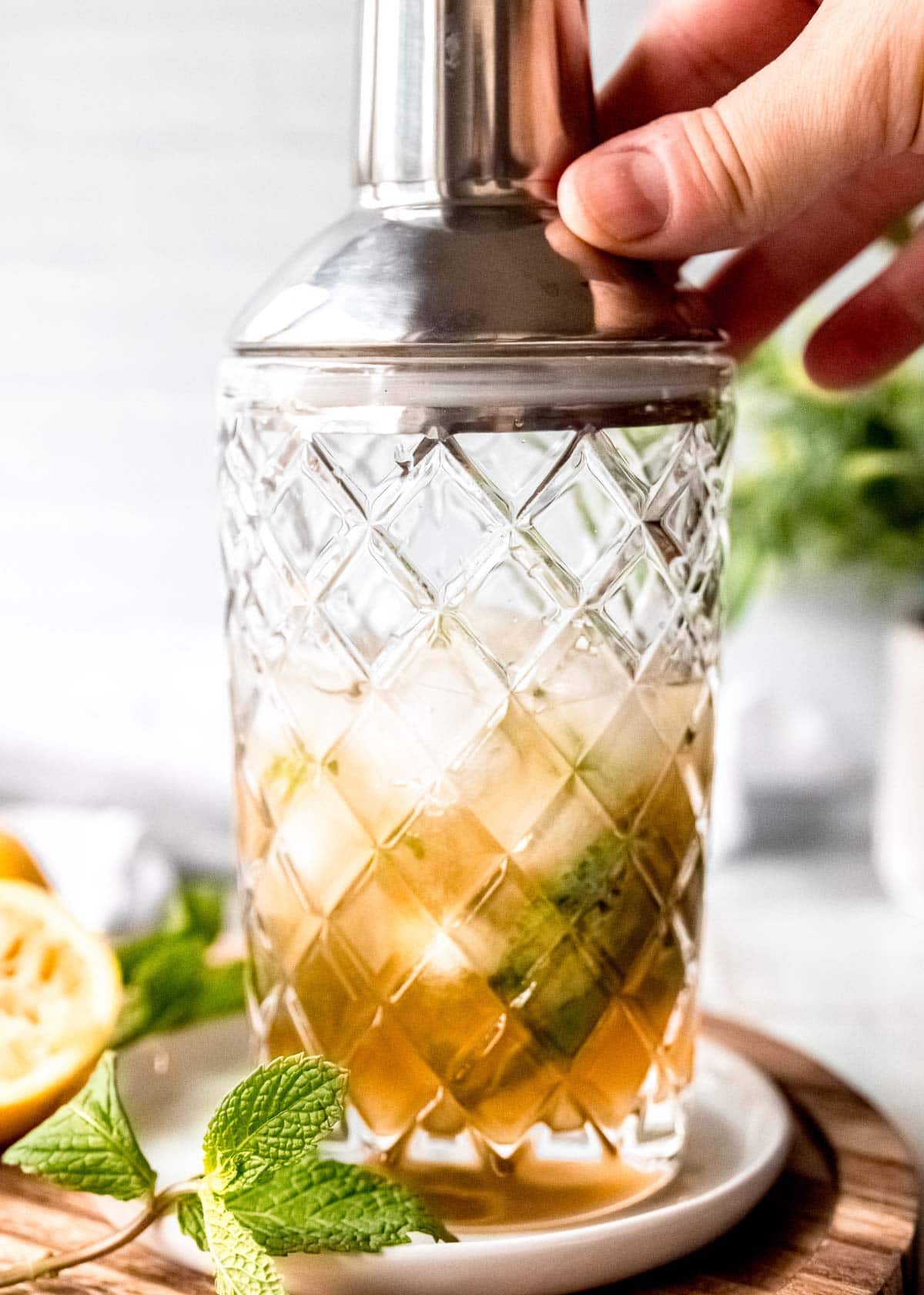 preparing mint julep in clear glass