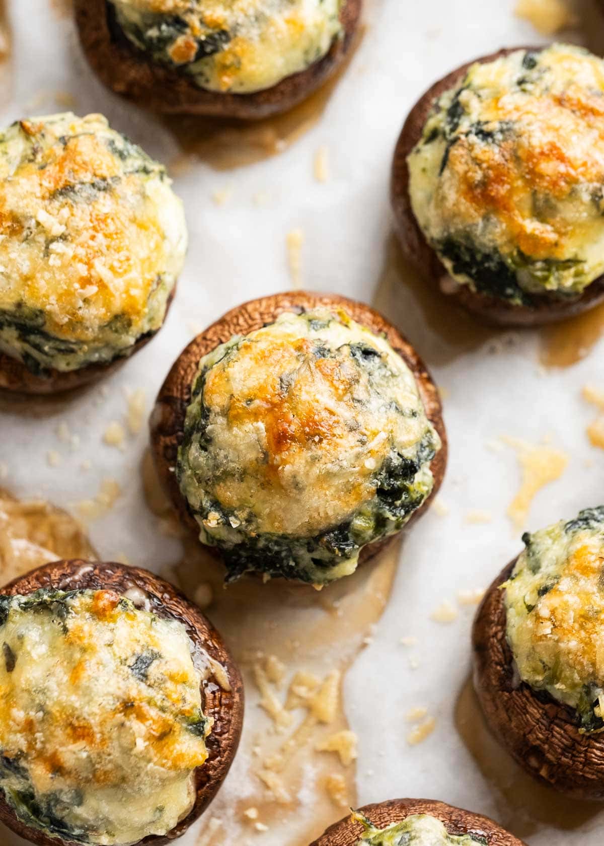 closeup shot of spinach stuffed mushroom topped with parmesan