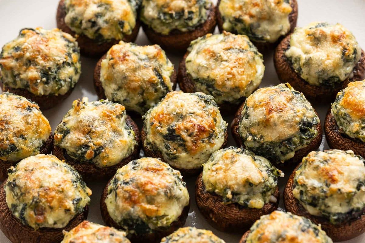a big plate of stuffed mushrooms with spinach, mozzarella, and parmesan