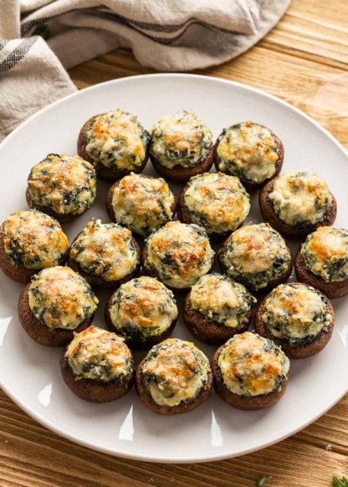 a plate full of cheesy spinach stuffed mushrooms