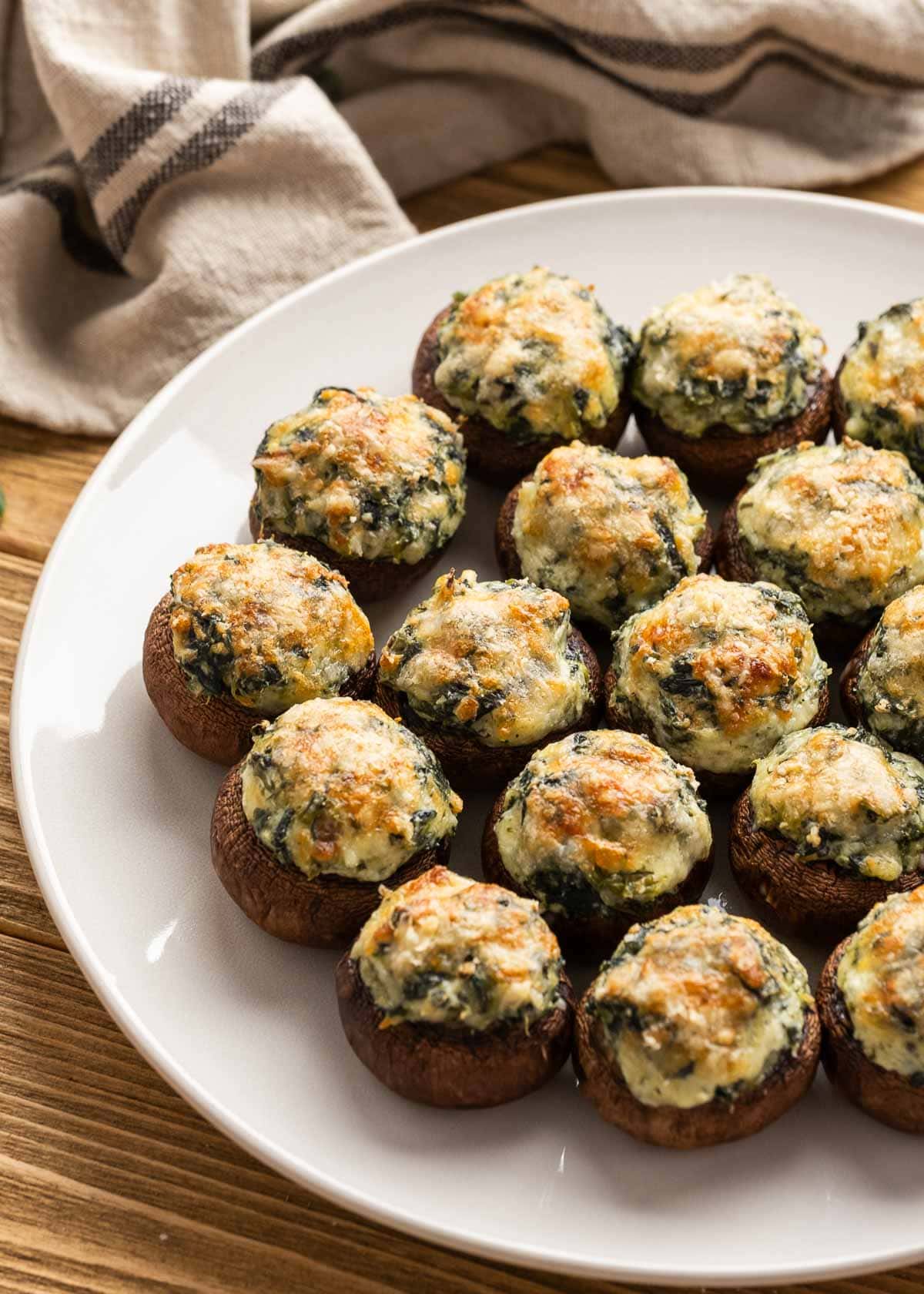 a few servings of spinach stuffed mushrooms on a white plate