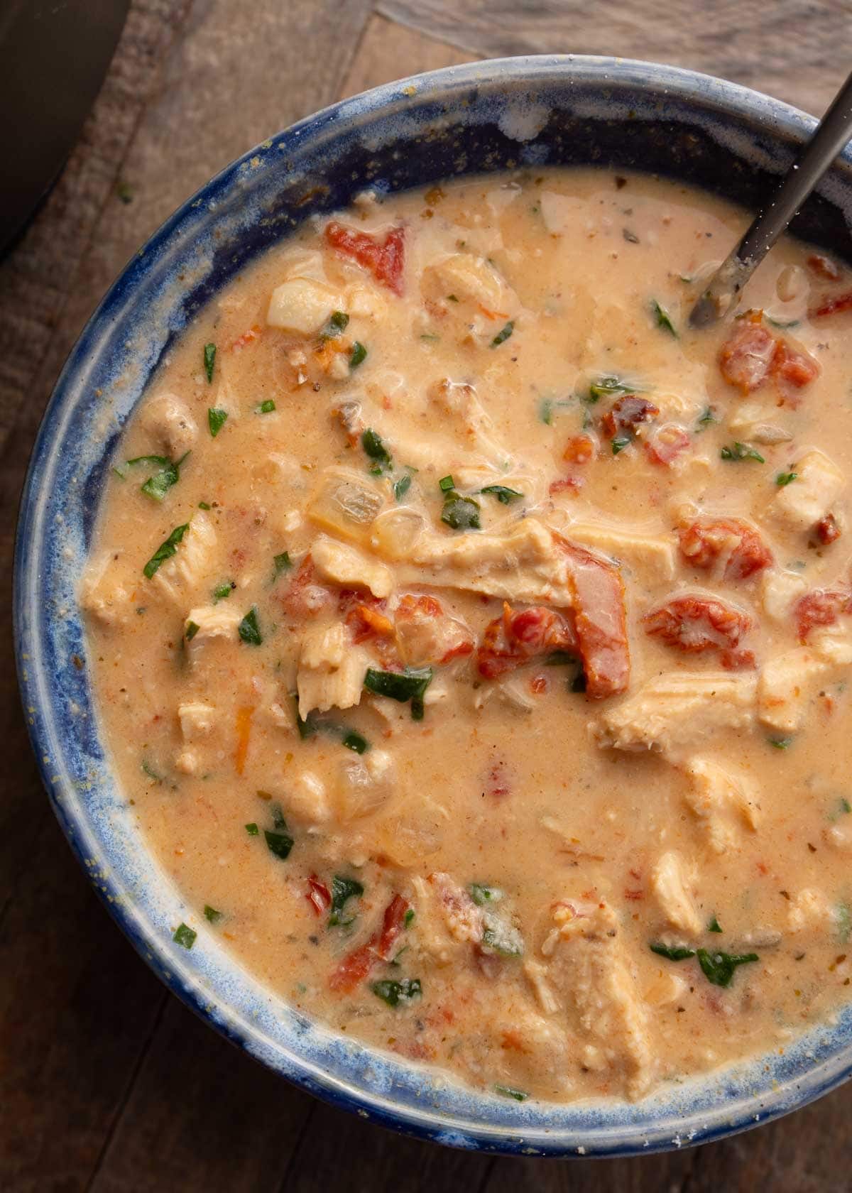 a closeup of creamy chicken soup in a blue bowl