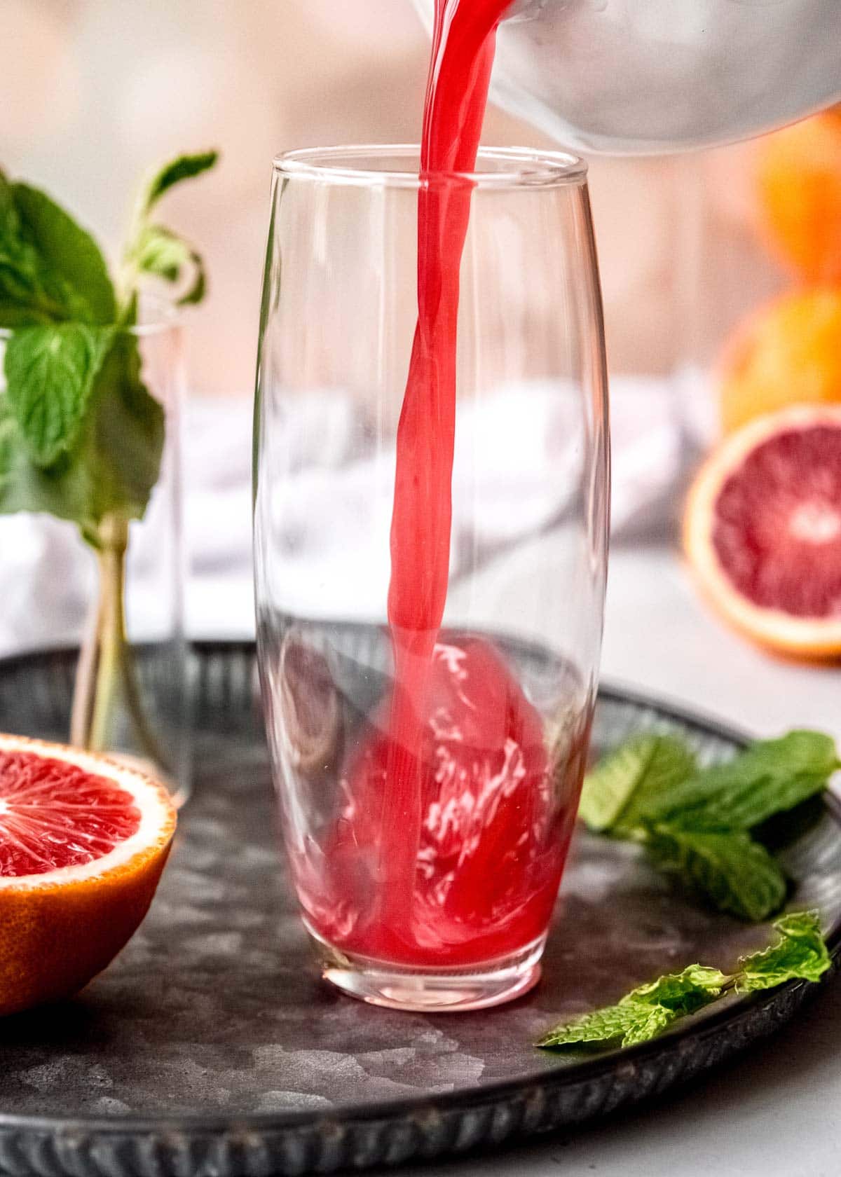 blood orange being poured into a flute