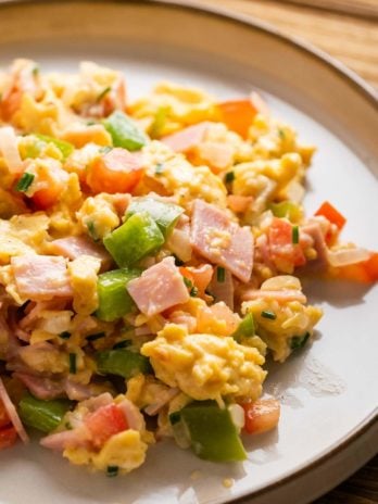 close up shot of loaded breakfast scramble on white plate