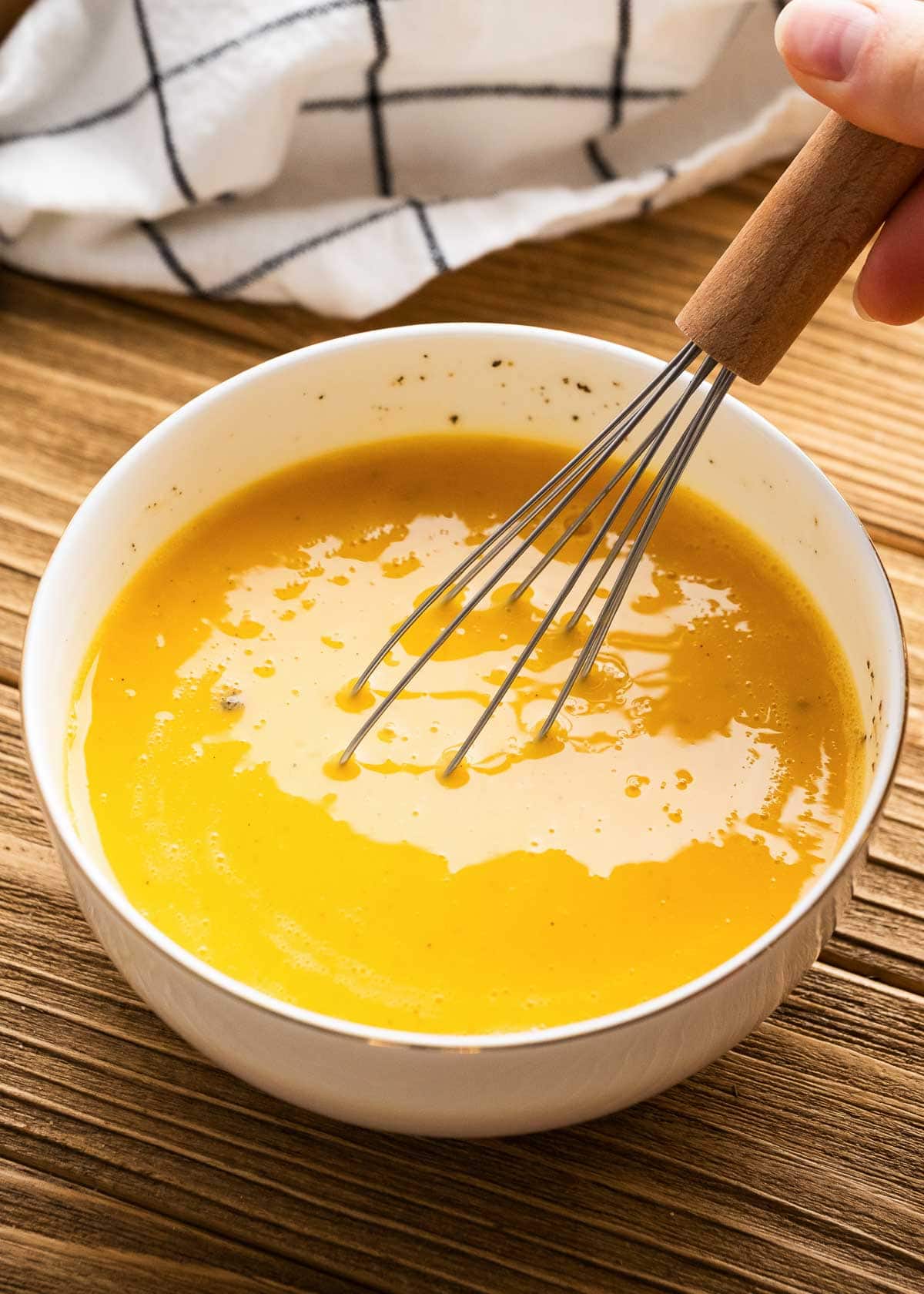 eggs being mixed in white bowl