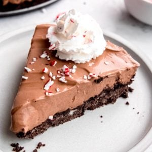 a perfect slice of no bake peppermint mocha pie with whipped cream and crushed candy canes