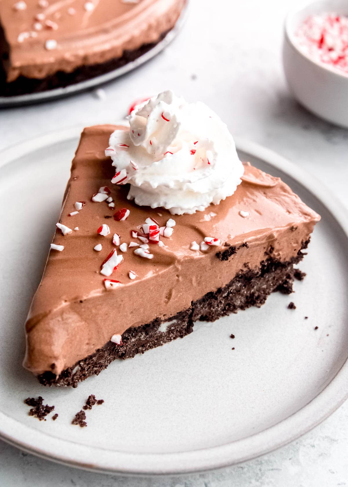 a perfect slice of no bake peppermint mocha pie with whipped cream and crushed candy canes