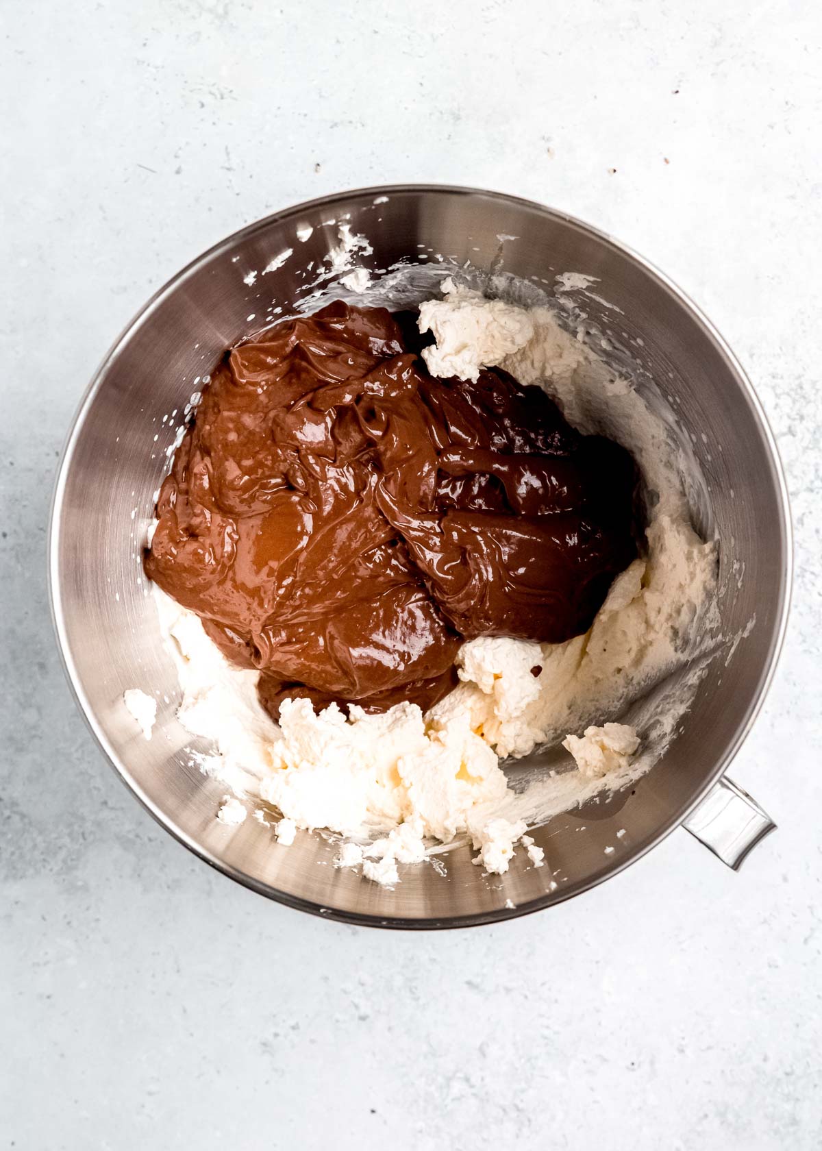 chocolate espresso peppermint pudding in a mixer bowl with whipped cream