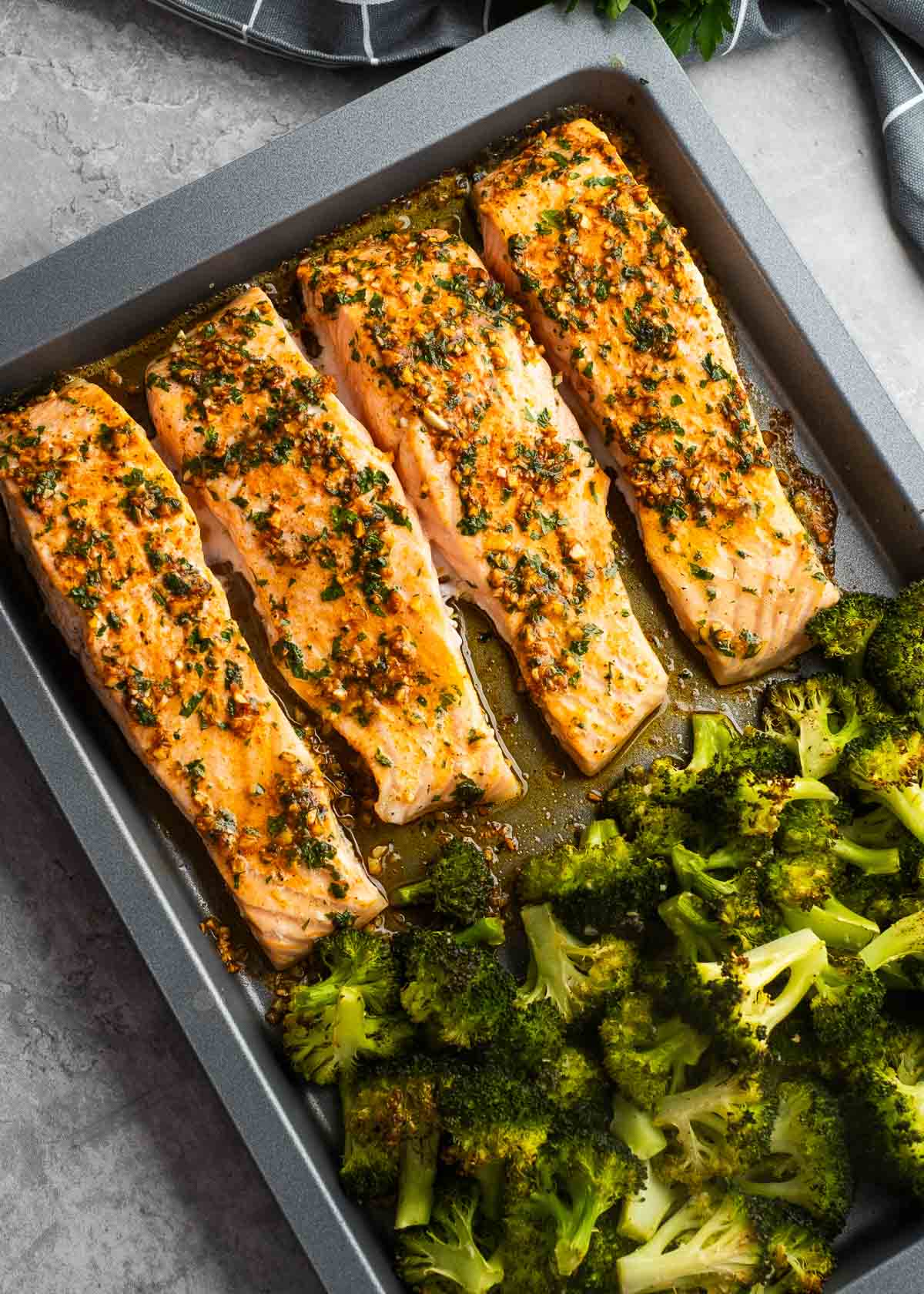 cooked salmon filets and broccoli on a sheet pan