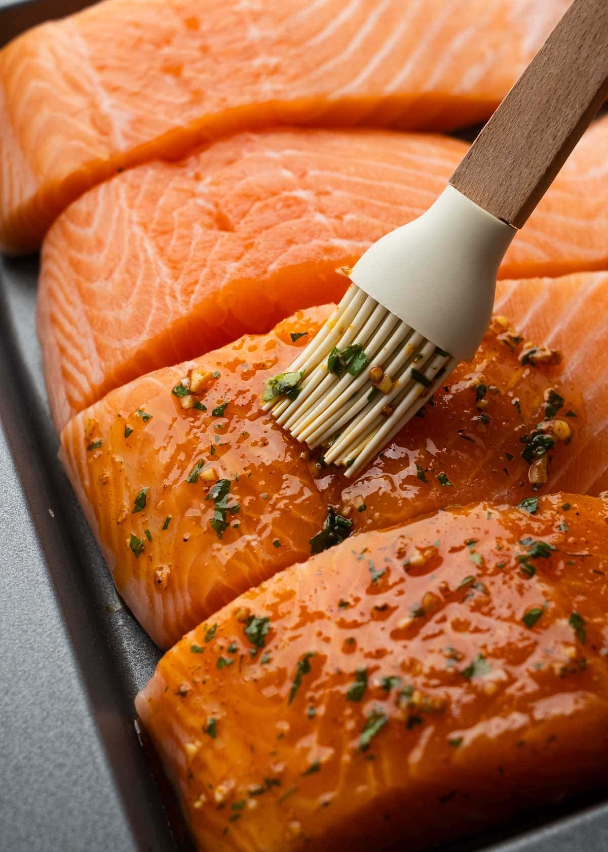 seasoning being spread on salmon filets