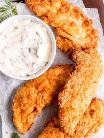 crispy buttermilk fried chicken tenders with a creamy homemade ranch dressing dip on the side