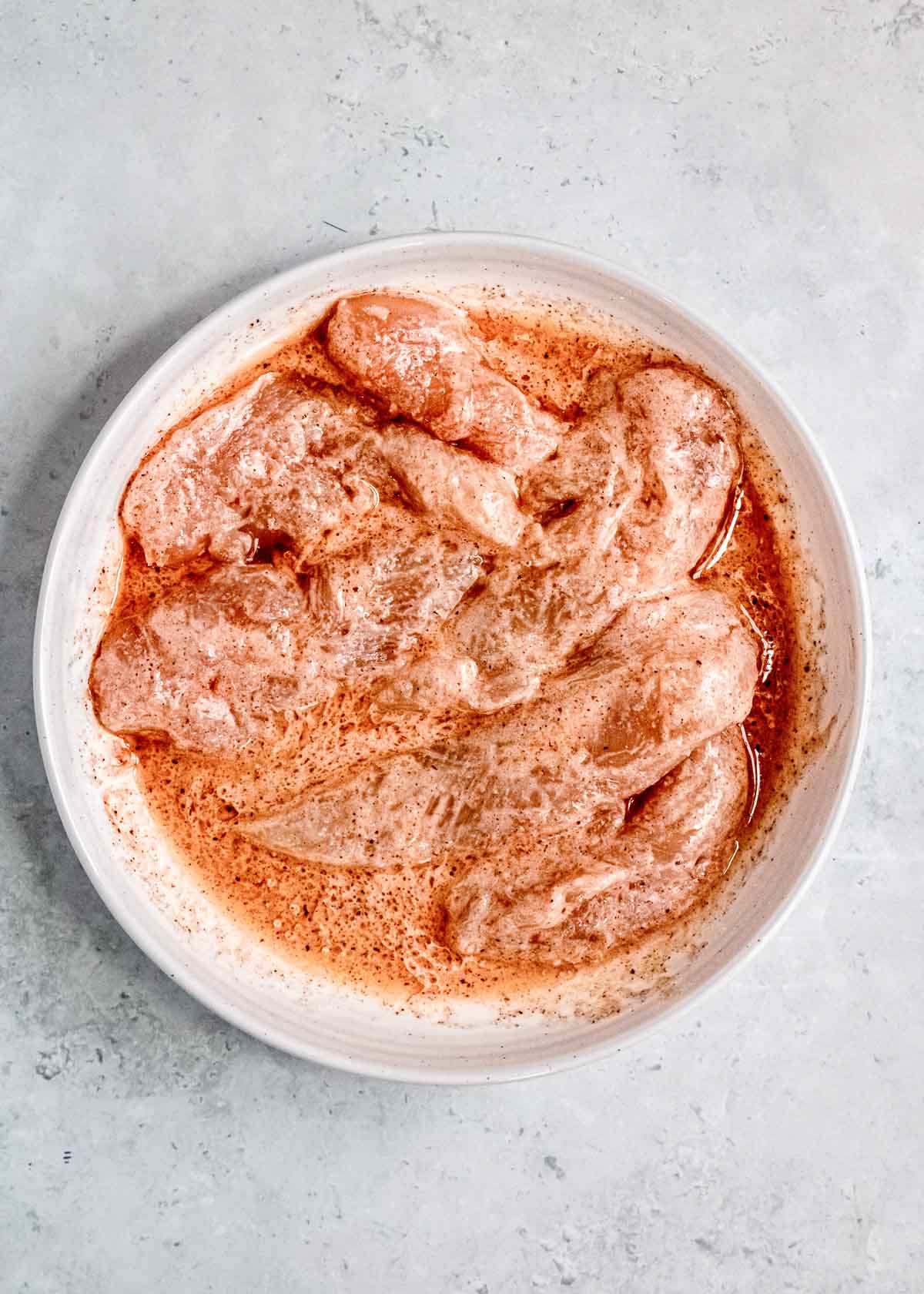 chicken tenderloins marinating in buttermilk, apple cider vinegar, avocado oil, and seasonings