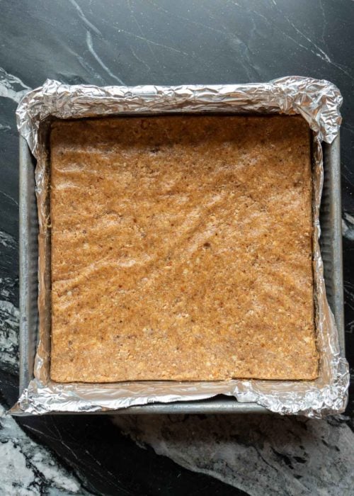 almond butter mixture pressed into an 8x8 dish lined with foil