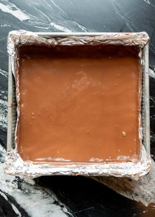 melted chocolate poured over the almond mixture in a pan