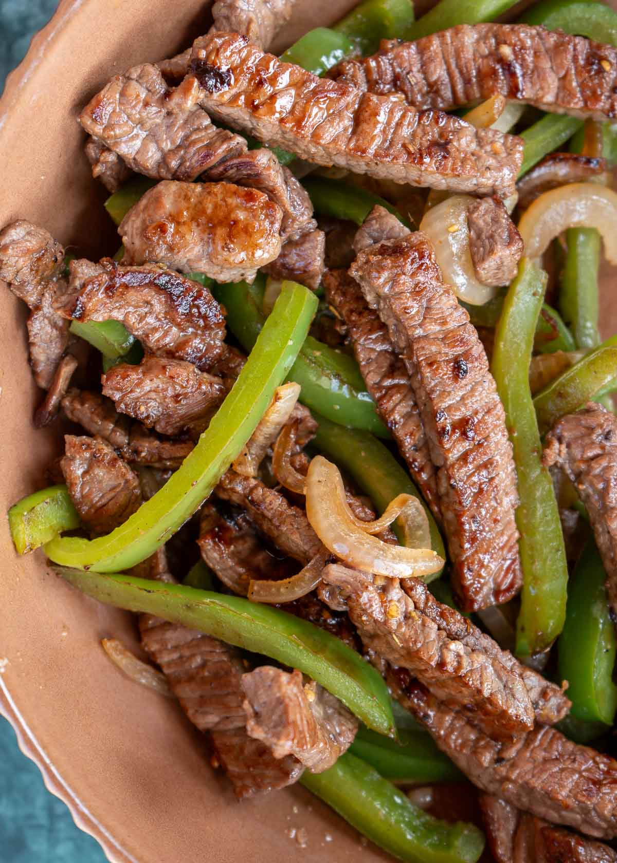 bowl of seared steak, peppers, and onions for steak wraps or quesadillas