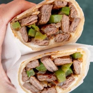 philly cheesesteak wraps with onions, peppers, and cheese in a tortilla
