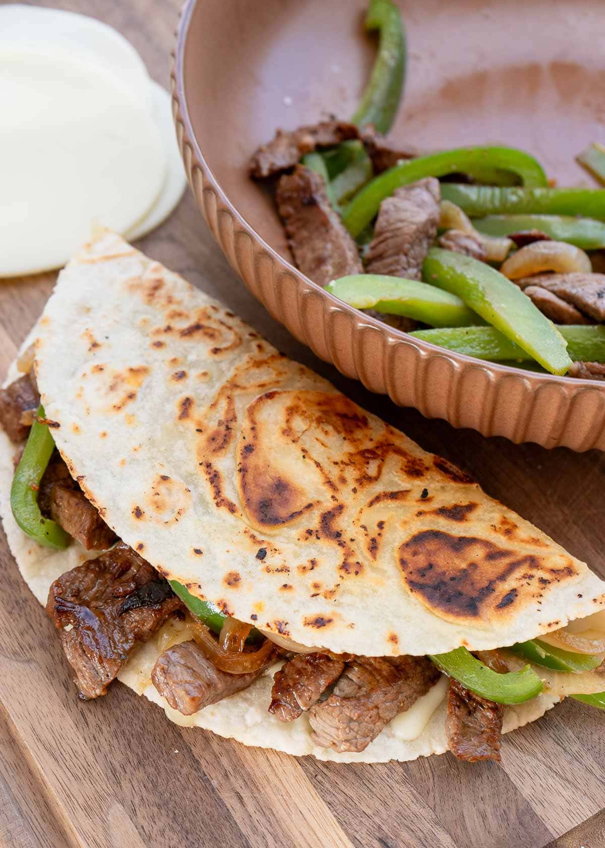 juicy steak, onions, and peppers in a fried quesadilla