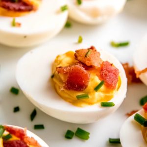 close up image of single deviled egg on white plate