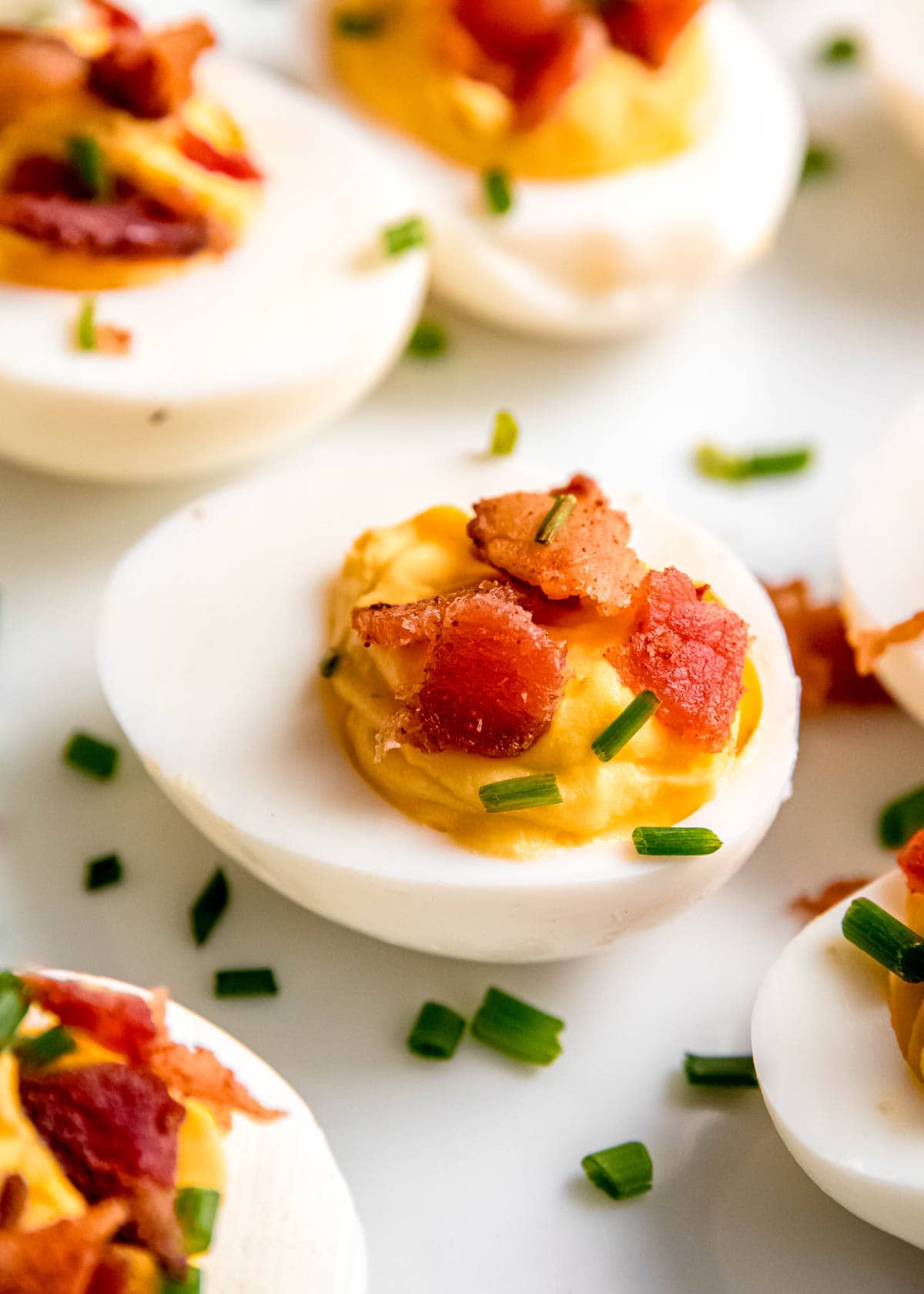 close up image of single deviled egg on white plate