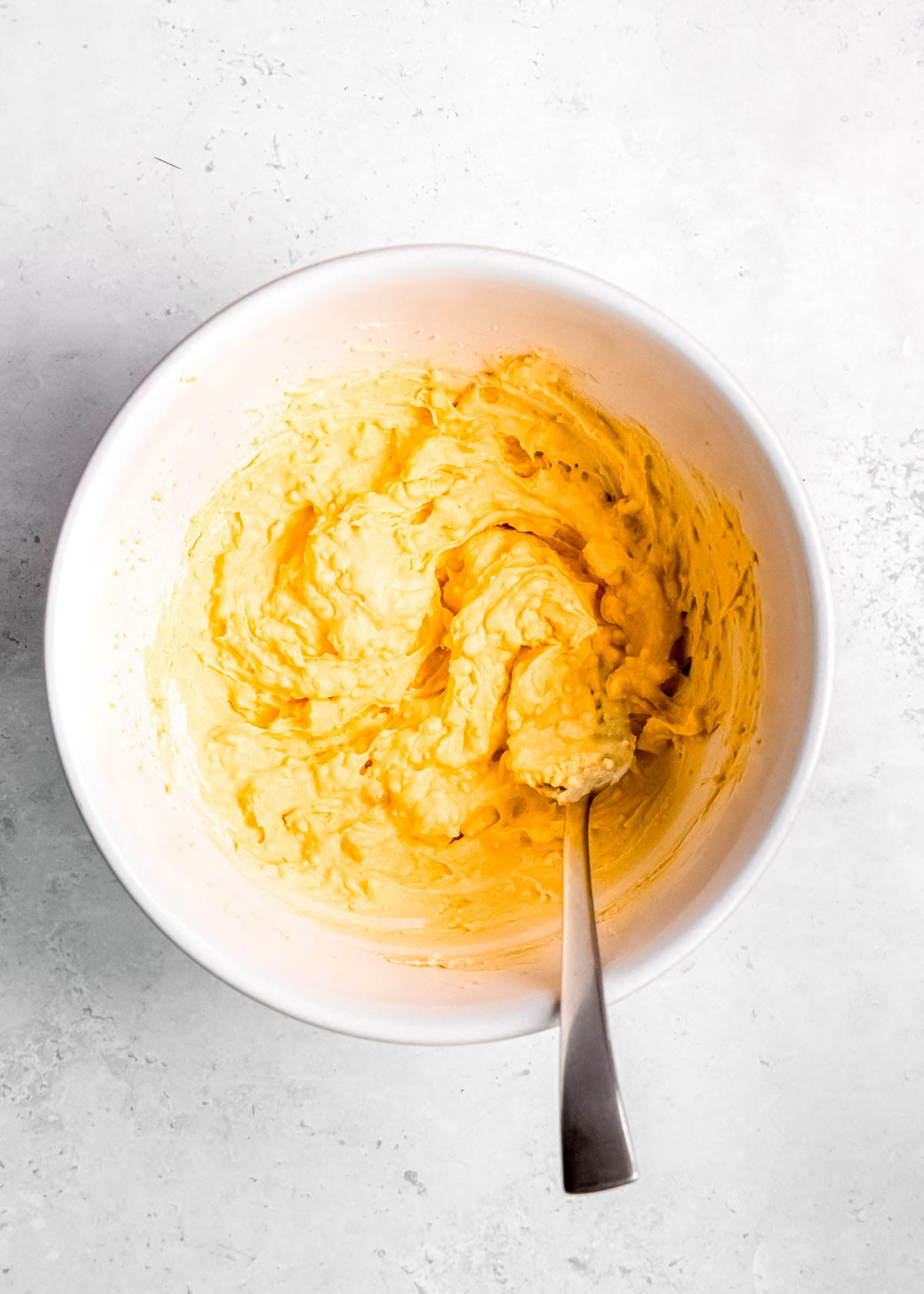 deviled egg filling being stirred in white bowl