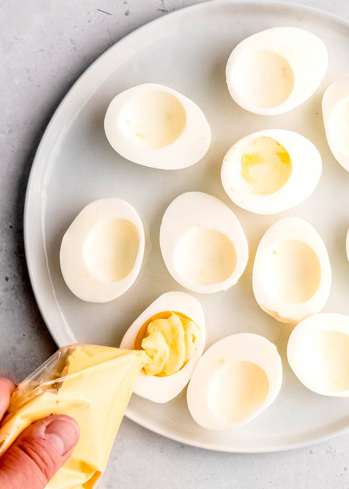 deviled egg filling being added to eggs