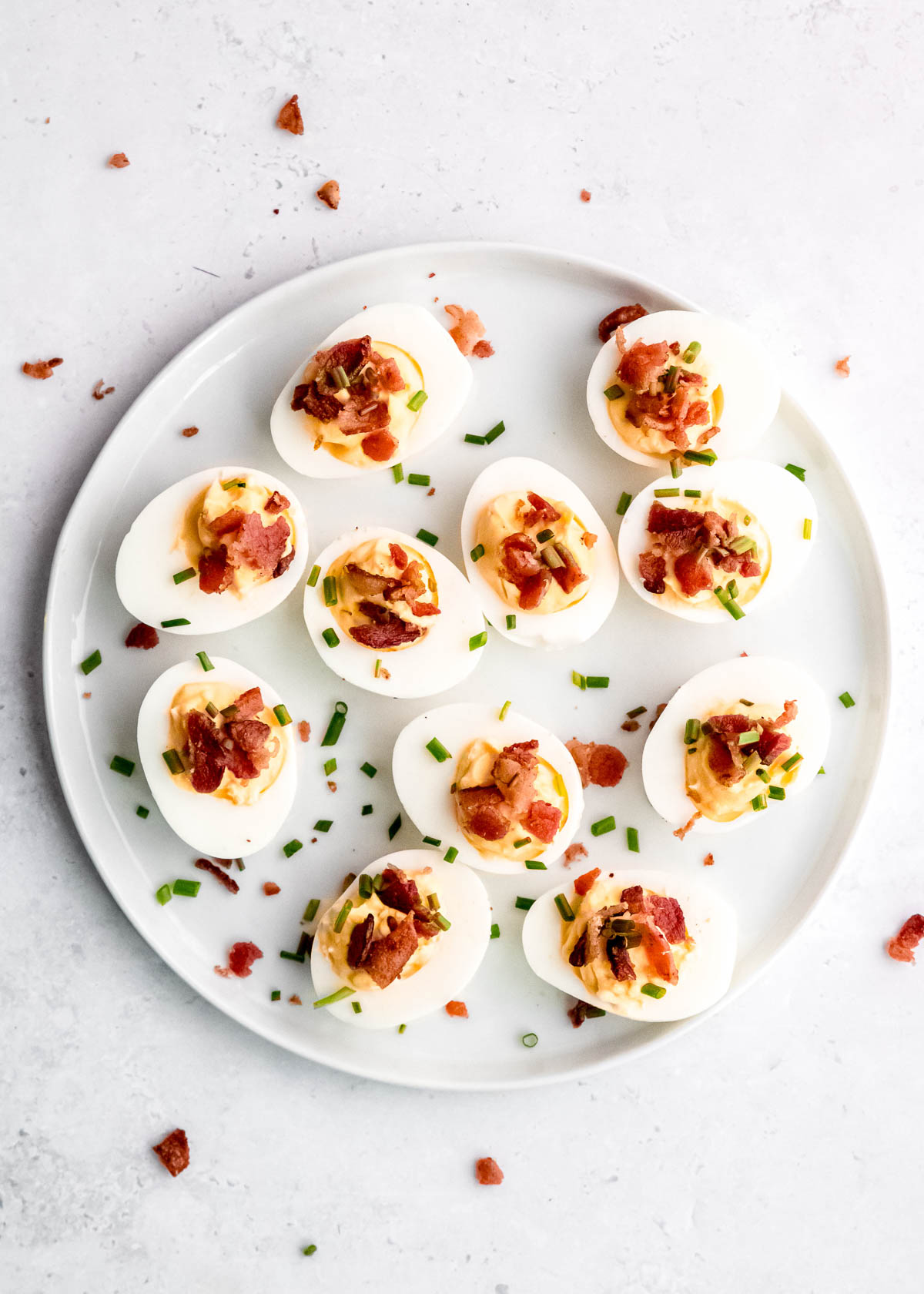 garnished deviled eggs on a white platter