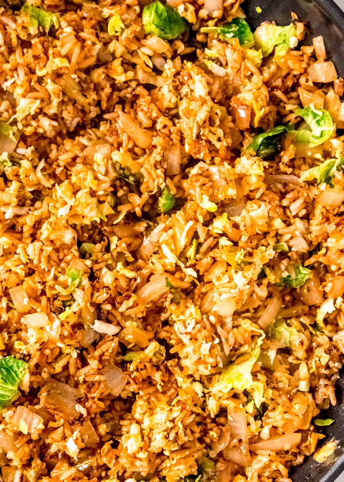 closeup shot of crispy brussels sprout fried rice in a skillet