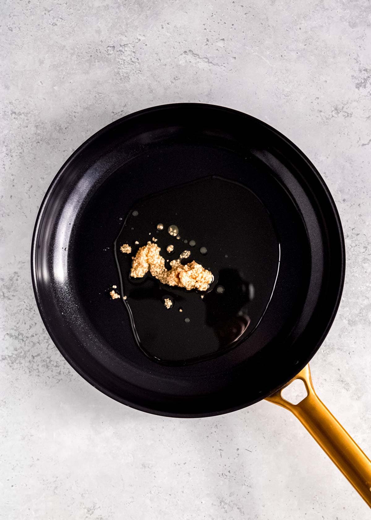garlic sauteing in sesame oil in a skillet