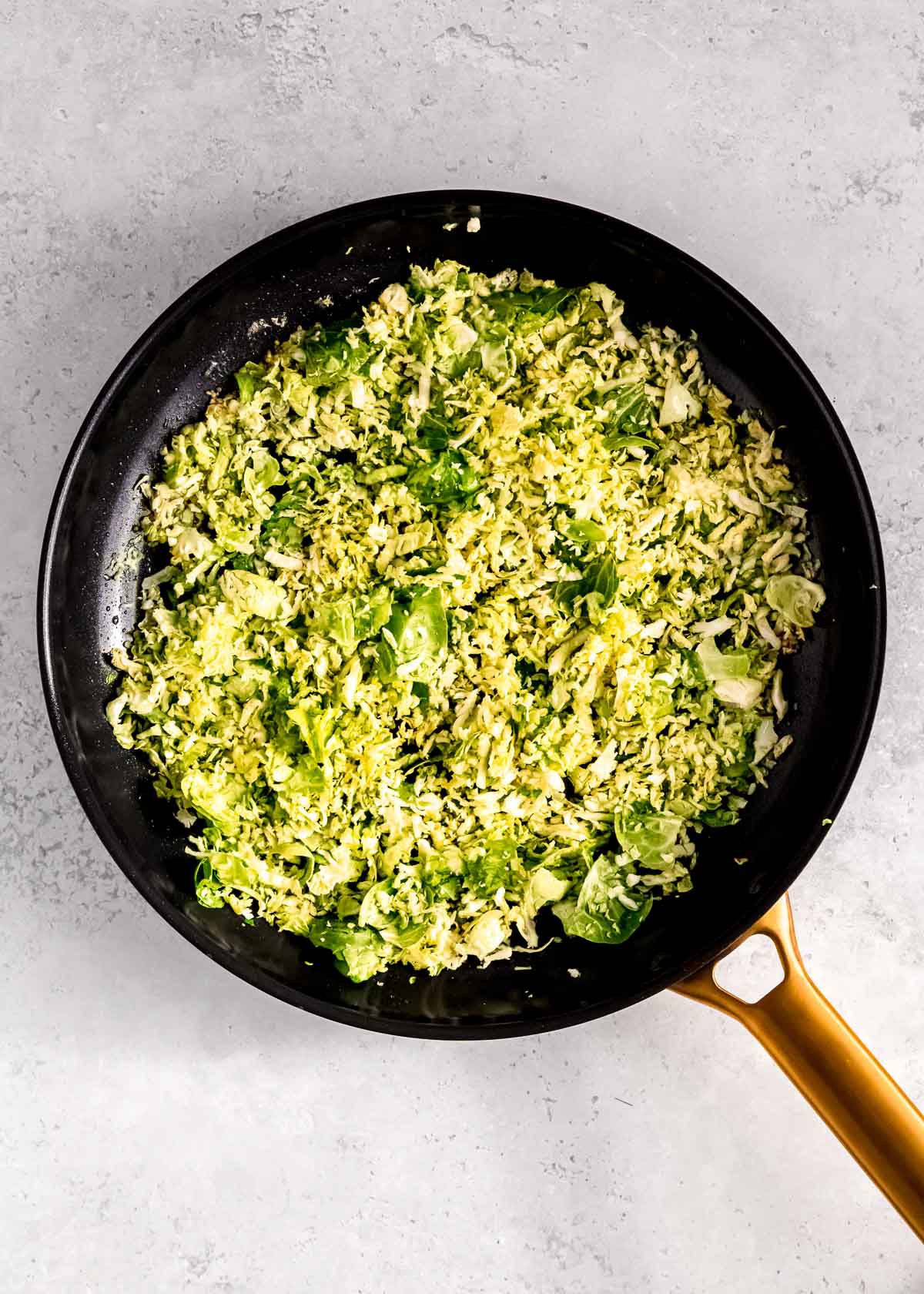 diced onion sauteing with brussels sprouts and garlic in sesame oil