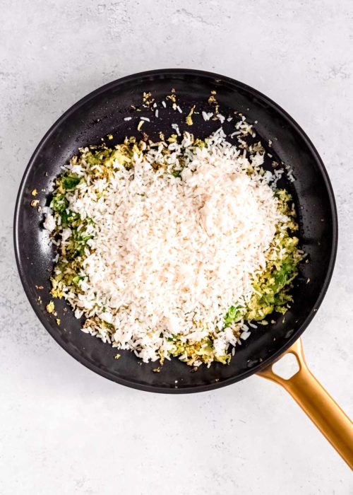 cooked, cold rice added to a pan with sauteed brussels sprouts and garlic