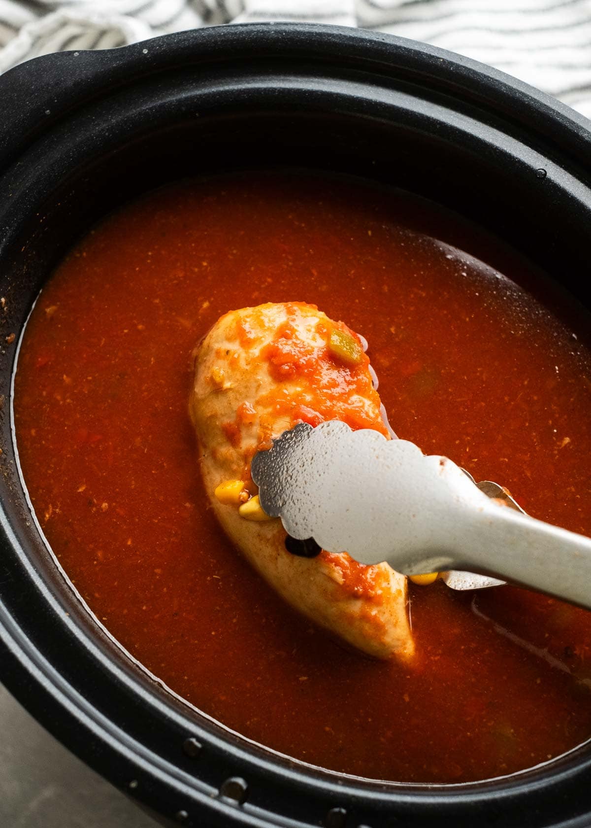 cooked chicken breasts in a slow cooker full of soup