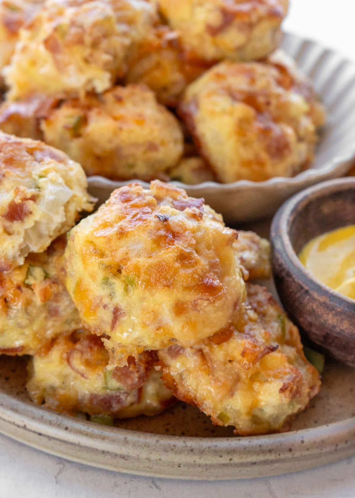 close up image of denver omelet bites on a white plate with dipping sauce