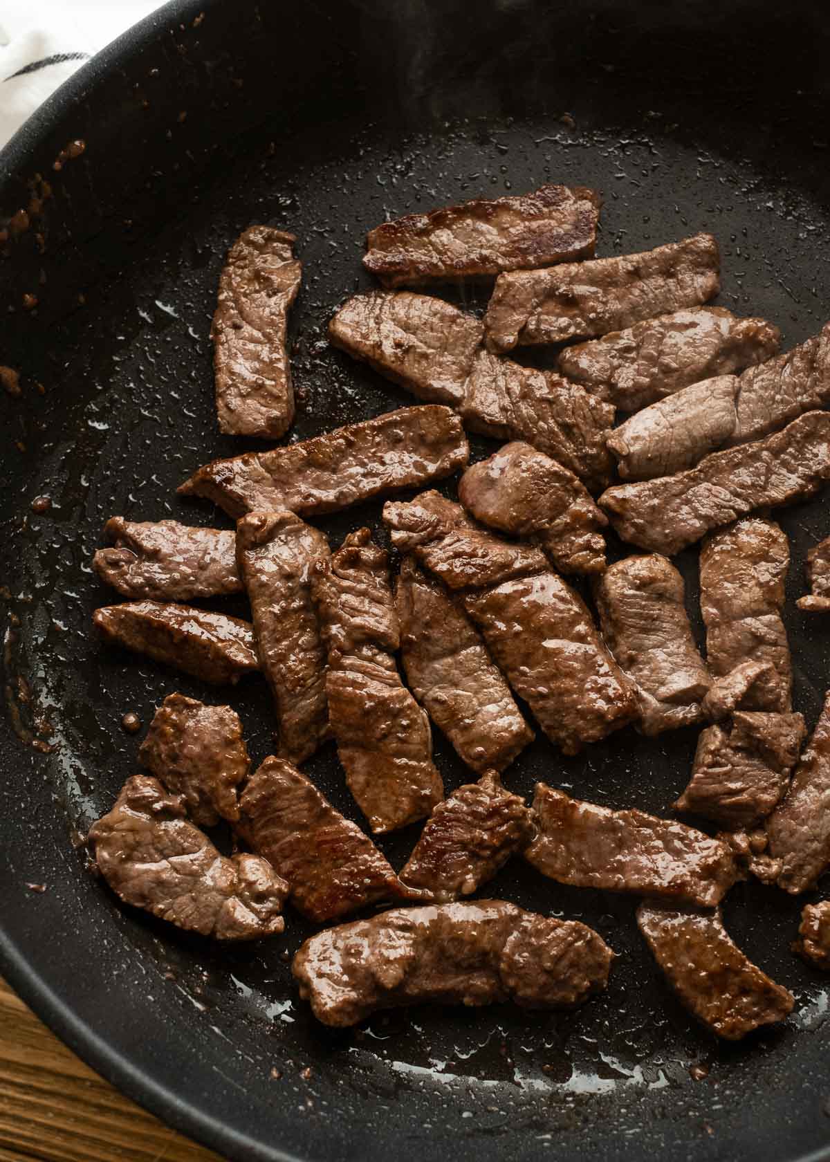 seared steak strips in a large skillet