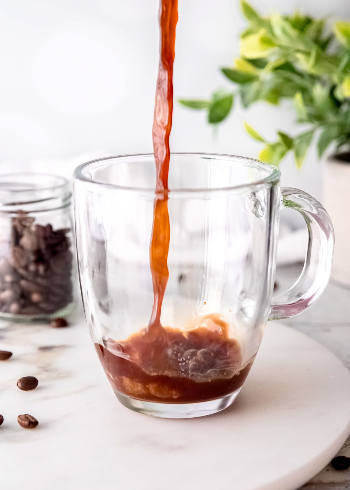 coffee being poured in clear coffee mug