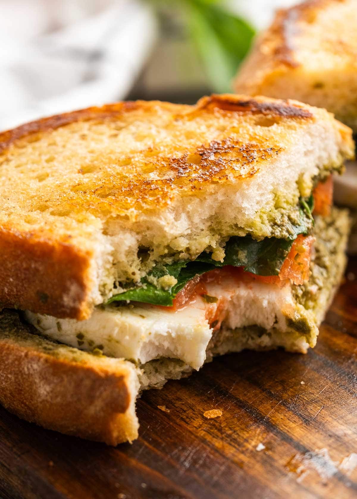 close up image of caprese sandwich o a wooden cutting board