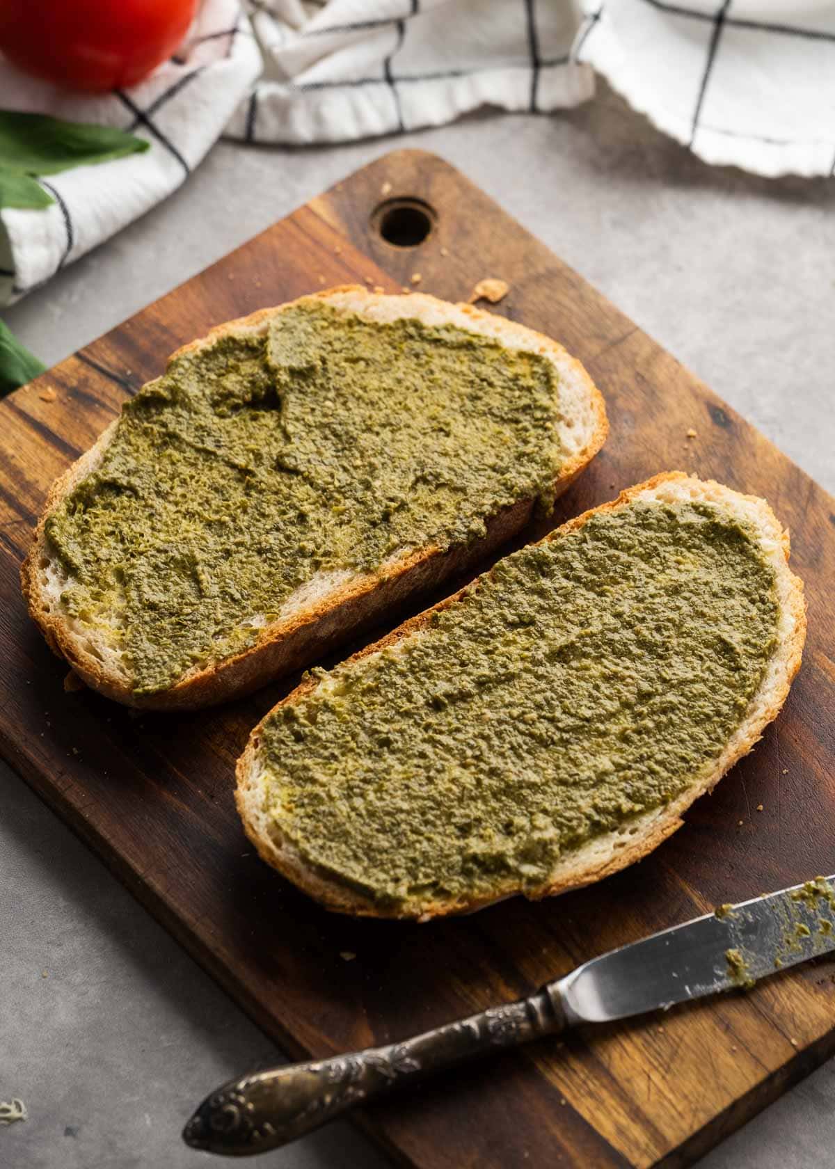 pesto being added to sliced bread
