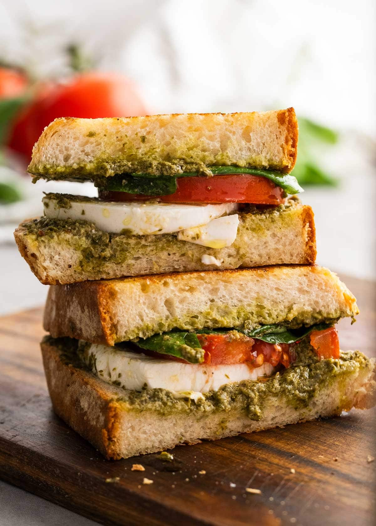 close up image of stacked caprese sandwiches on wooden cutting board