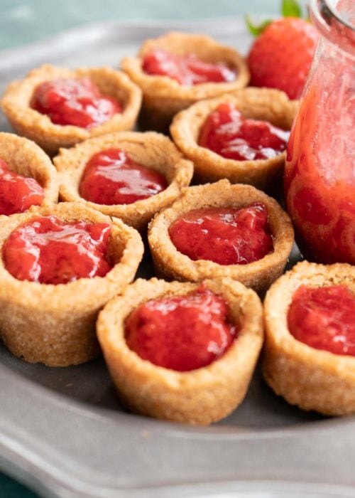 peanut butter and jelly cookie cups filled with strawberry sauce