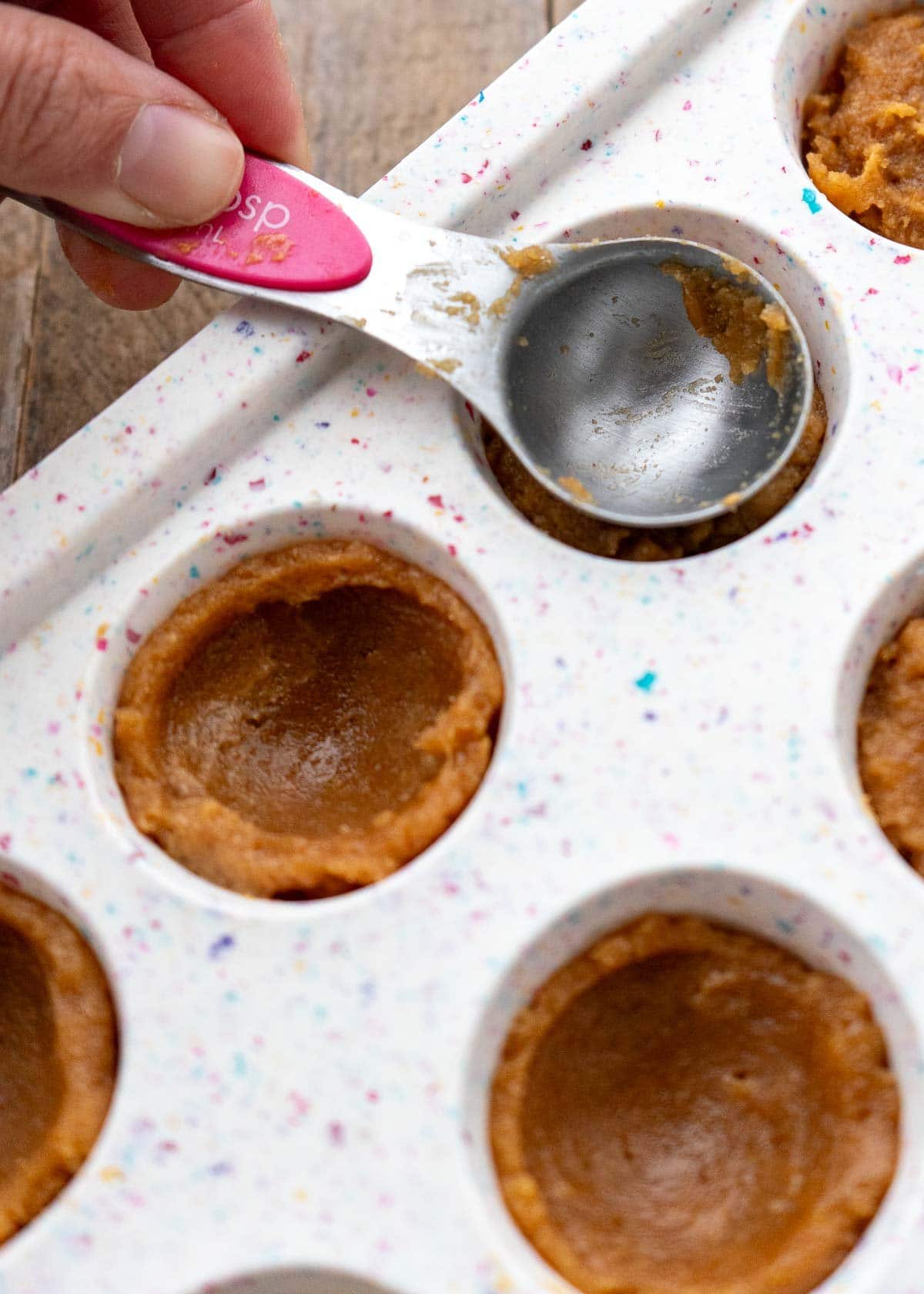 peanut butter cookie dough pressed into a silicone mini muffin pan